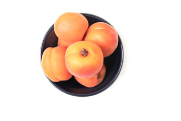 ripe apricots in plate on the table. Orange apricots fruits in bowl. Juicy apricots nutrition.
