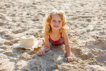 little girl lying on the beach on the sand summer