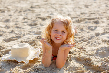 little girl lying on the beach on the sand summer
