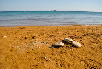 3 stones in a red beach