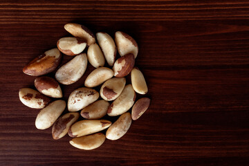 Pile of Brazilian nuts on wooden table. Brazil nut or Bertholletia. Top view