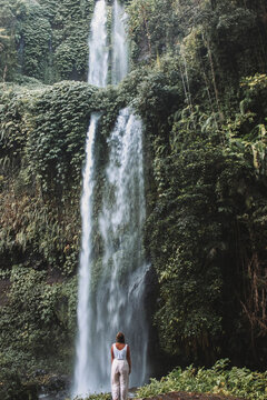 Woman standing and facing near waterfalls