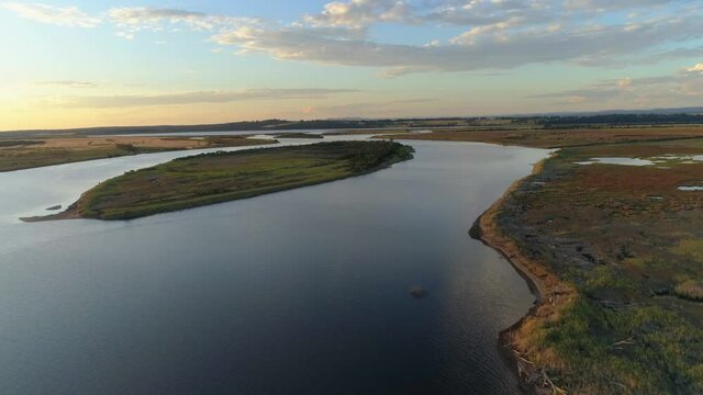 Forward flight rising high over Snowy River revealing the horizon at sunset. Marlo, Australia.