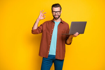 Photo of young handsome man gesture okey sign perfect good choose recommend promo laptop isolated...
