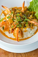 Shrimp and Grits. Grits and old bay seasoned jumbo shrimp topped with spices and micro greens. Classic American Diner Style Breakfast or Brunch menu item. Traditional low country southern staple. 