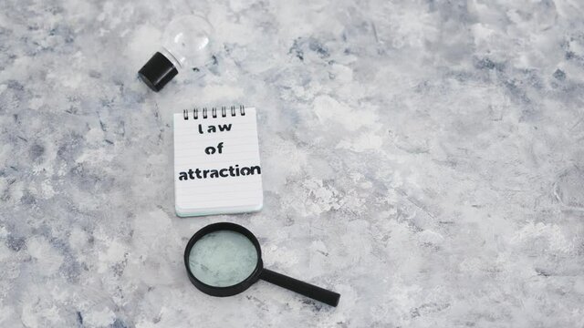 law of attraction notepad with light bulb and magnifying glass symbol of introspection and mindset shift