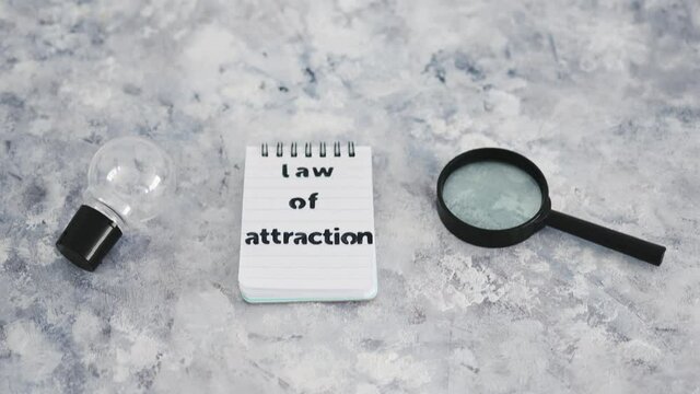 law of attraction notepad with light bulb and magnifying glass symbol of introspection and mindset shift
