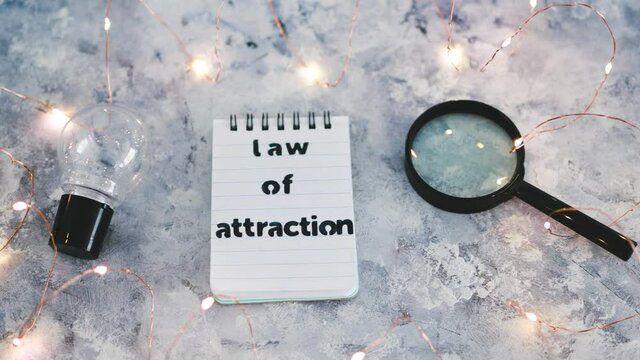 law of attraction notepad with light bulb and magnifying glass symbol of introspection and mindset shift