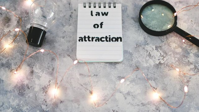 law of attraction notepad with light bulb and magnifying glass symbol of introspection and mindset shift