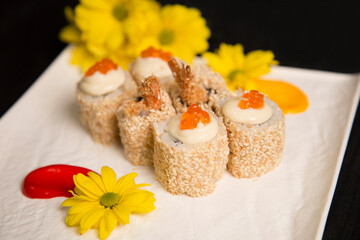 Side view of Japanese sushi roll Ebi Tempura with shrimp served with red caviar on top. Yellow...