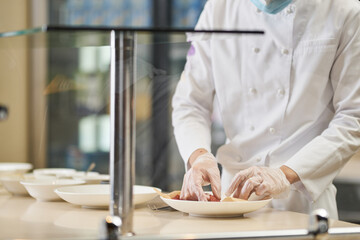 Obraz na płótnie Canvas Chef in uniform preparing plates with food