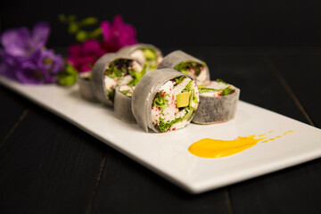 Side view of healthy Japanese no rice sushi roll with crab meat, avocado, lettuce wrapped in daikon...