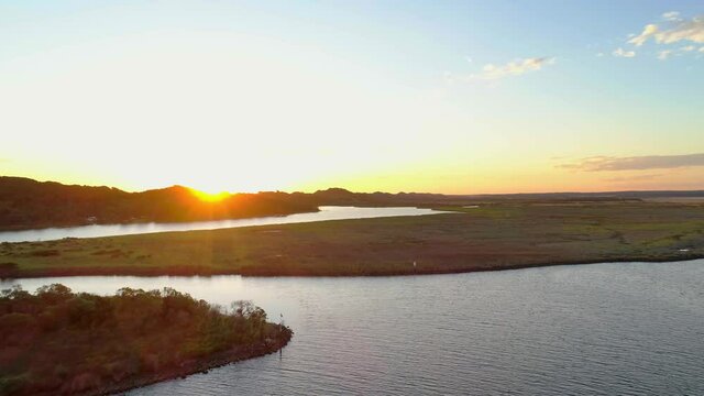Forward flight rising high over Snowy River estuary at sunset