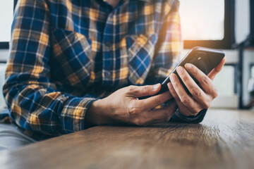 man work using cell phone hand holding mobile texting message contact us.chatting,search internet information in office.technology device communication connecting