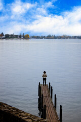 Single lady standing alone on edge of footbridge with  freedom moment and peaceful atmosphere in nature,loneliness concept,Back view.