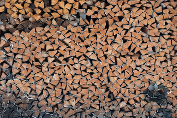 firewood for heating the stove in winter, neatly stacked for storage in a woodpile. Horizontal photo. Background, abstraction.