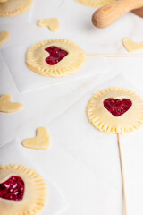 The process of making small cherry pies on sticks on Valentine's Day. Raw cherry pie pops.