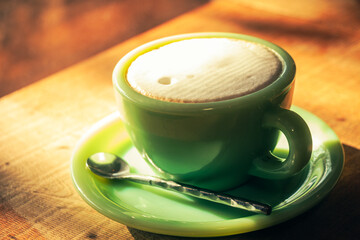 A Japanese cafe, a coffee cup with a hot latte, illuminated by the light coming in.