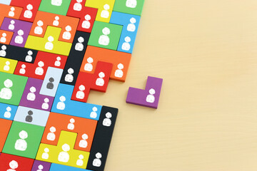 image of tangram puzzle blocks with people icons over wooden table ,human resources and management...