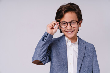 Close up portrait of a charming young boy in glasses and formal suit like future businessman...