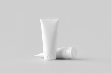 White plastic cream tube mockup on a grey background.