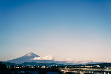Fototapeta na wymiar Mt. Fuji seen with warm tone on the left over the road over the Japanese bridge (Horizontal)