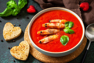 Traditional homemade gazpacho cold soup. Tomato soup puree gazpacho with tomatoes served seafood on a stone background.