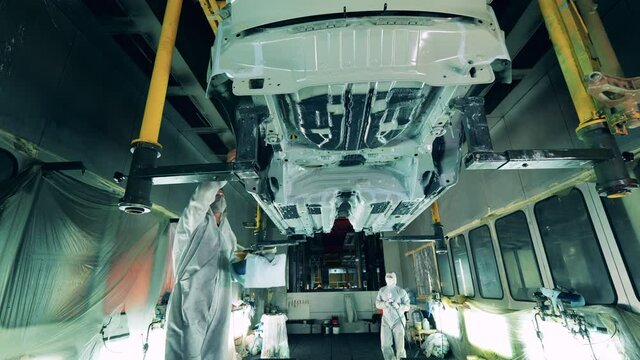 Factory workers are checking car bottom after galvanizing