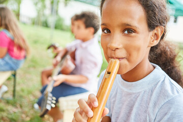 Girl learns to play the flute in the summer camp course - obrazy, fototapety, plakaty