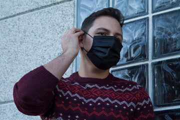 young man with medical mask on his face protecting himself against viruses and infections in the street
