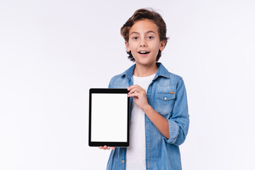 Surprised small male kid showing tablet screen isolated over white background