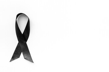 Black awareness ribbon isolated on a white background. Top view