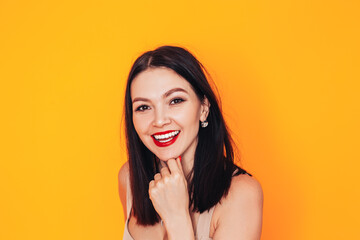 Young woman standing in front of a yellow background. Dental clinic advertisement. Health care. Do-it-yourself makeup at home