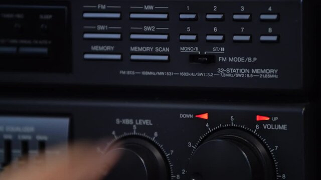 Close-up man's hand turns on the mono mode on the retro tape recorder. Listen to music in mono mode.
