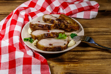 Baked pork belly in a plate on wooden table