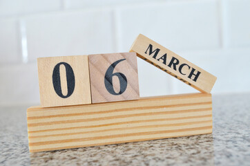 March 6, Cover design with number cube on a white background and granite table.