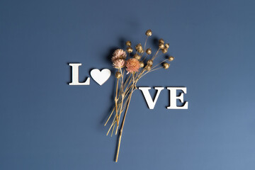 Creative flat lay of word love on soft color  background with natural plants © bedya