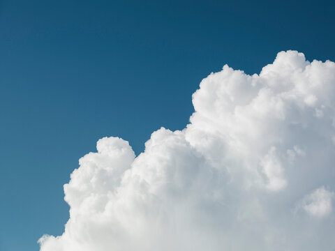 Fluffy white clouds in sunny blue sky
