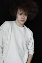 Fototapeta na wymiar Portrait of young man in white with voluminous curly hair