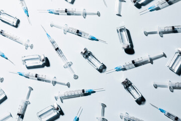 COVID-19 vaccine vials and syringes on white background
