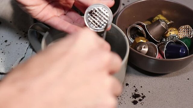 Hombre vaciando c&aacute;psulas de caf&eacute; para llavarlas a reciclar 