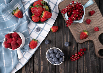 Mix berries on a wooden table, strawberries, blueberries, raspberry and red currants in high resolution 