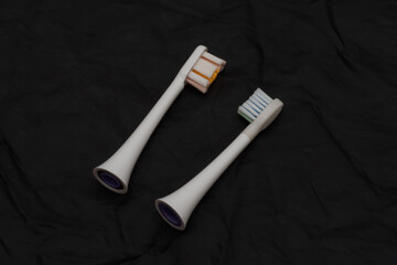 two spare heads for an electric toothbrush on a black background
