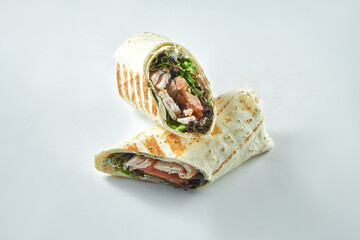 Roll with turkey, vegetables and salad leaves. Diet shawarma with white meat in lavash on a white...