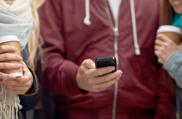 technology, friendship and people concept - group of friends with smartphone drinking coffee outdoors