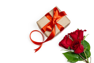 Holidays and Valentin’s day romantic flat lay. Gift box with red ribbon and red rose on white background.