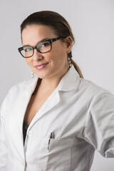 Ritratto di bella dottoressa bionda con occhiali da vista e capelli raccolti che guarda con un bellissimo sorriso, isolata su sfondo bianco