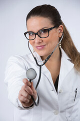 Dottoressa bionda con occhiali da vista e capelli raccolti in camice bianco fa un bel sorriso...