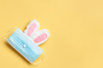 Easter and quarantine. Rabbit in a protective medical mask on a yellow background.