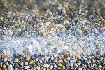 Pebbles on the beach with ice flowers